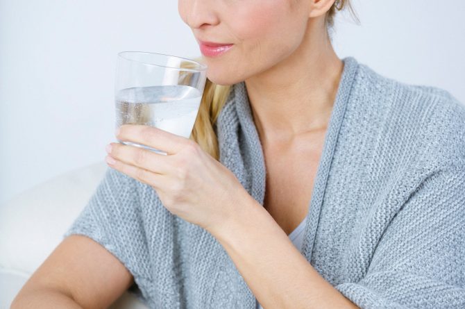 Frau middle-age in beiger Stola mit Wasserglas_3668