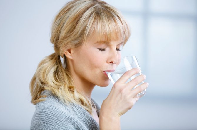 Frau mit geschlossenen Augen trinkt Heilwasser_3881