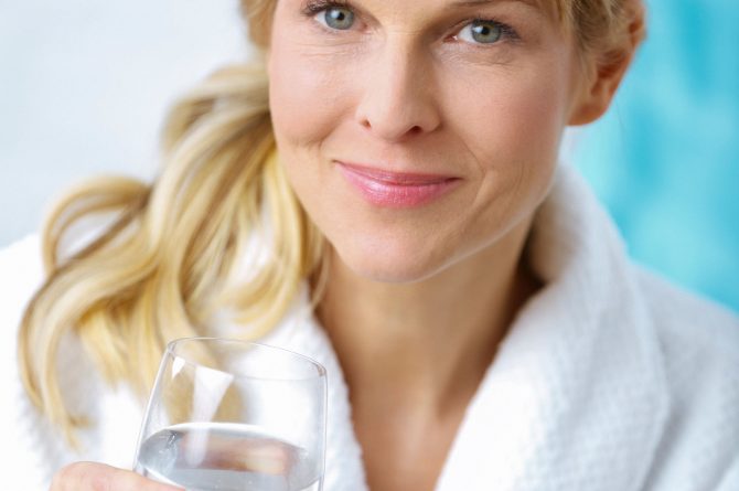 Wellness_Frau im Bademantel mit Heilwasserglas_4922